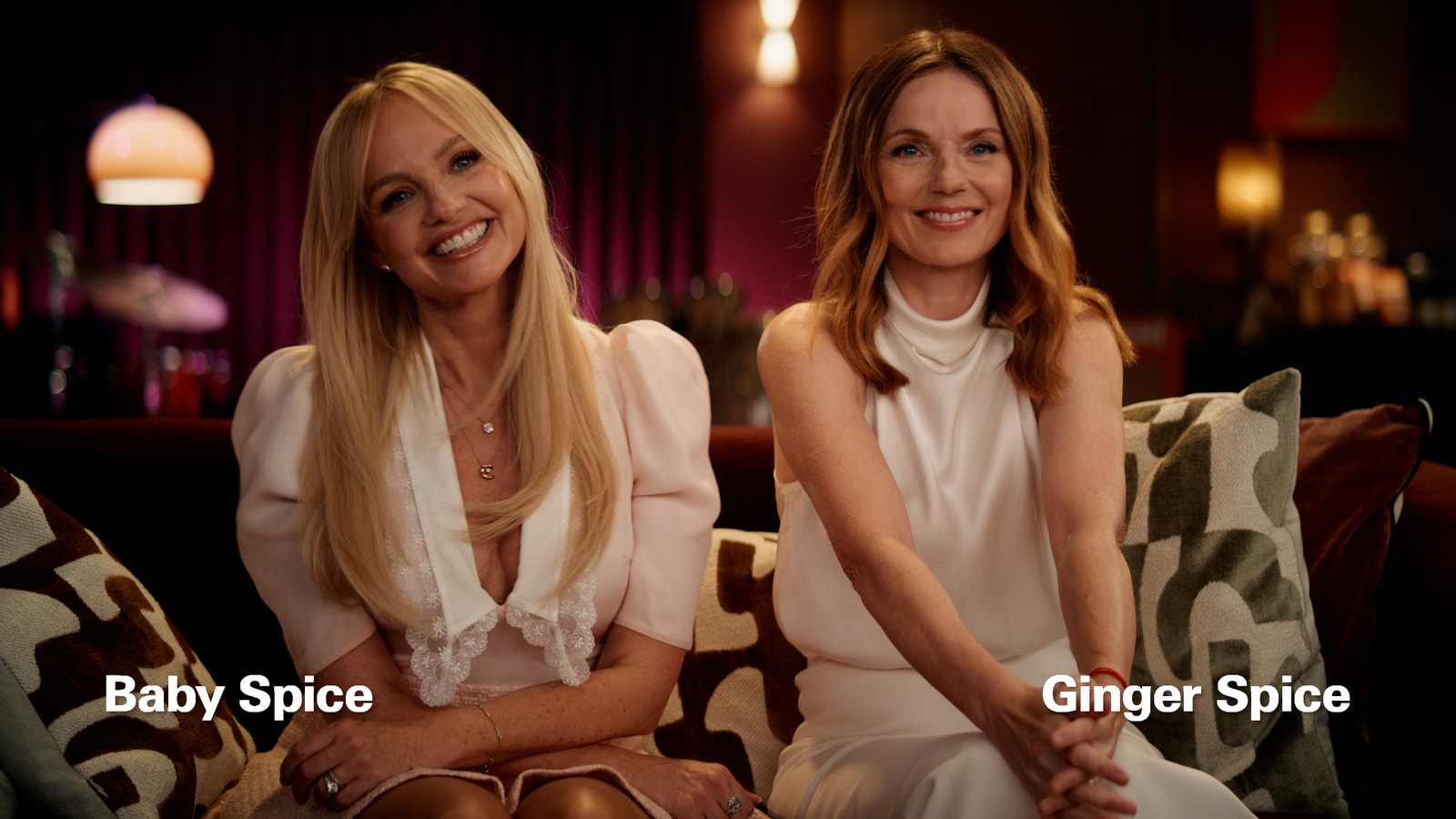 Baby Spice and Ginger Spice sit together on a recording-studio couch in Dunkin’s Pumpkin Spice reunion ad.