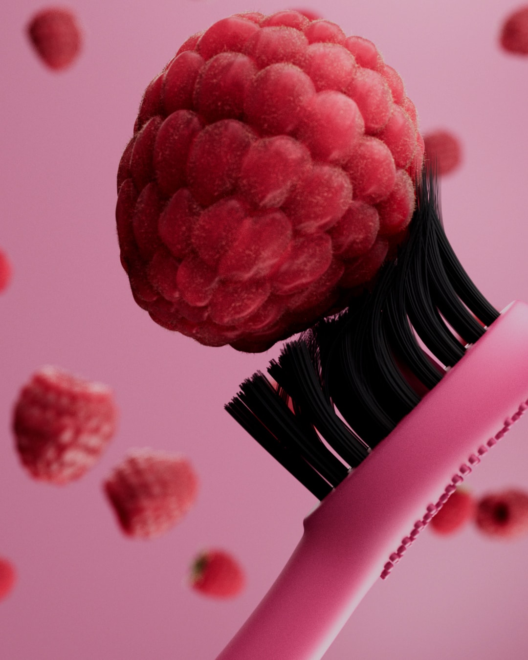 A raspberry balances on the black bristles of a pink Burst Berry toothbrush.