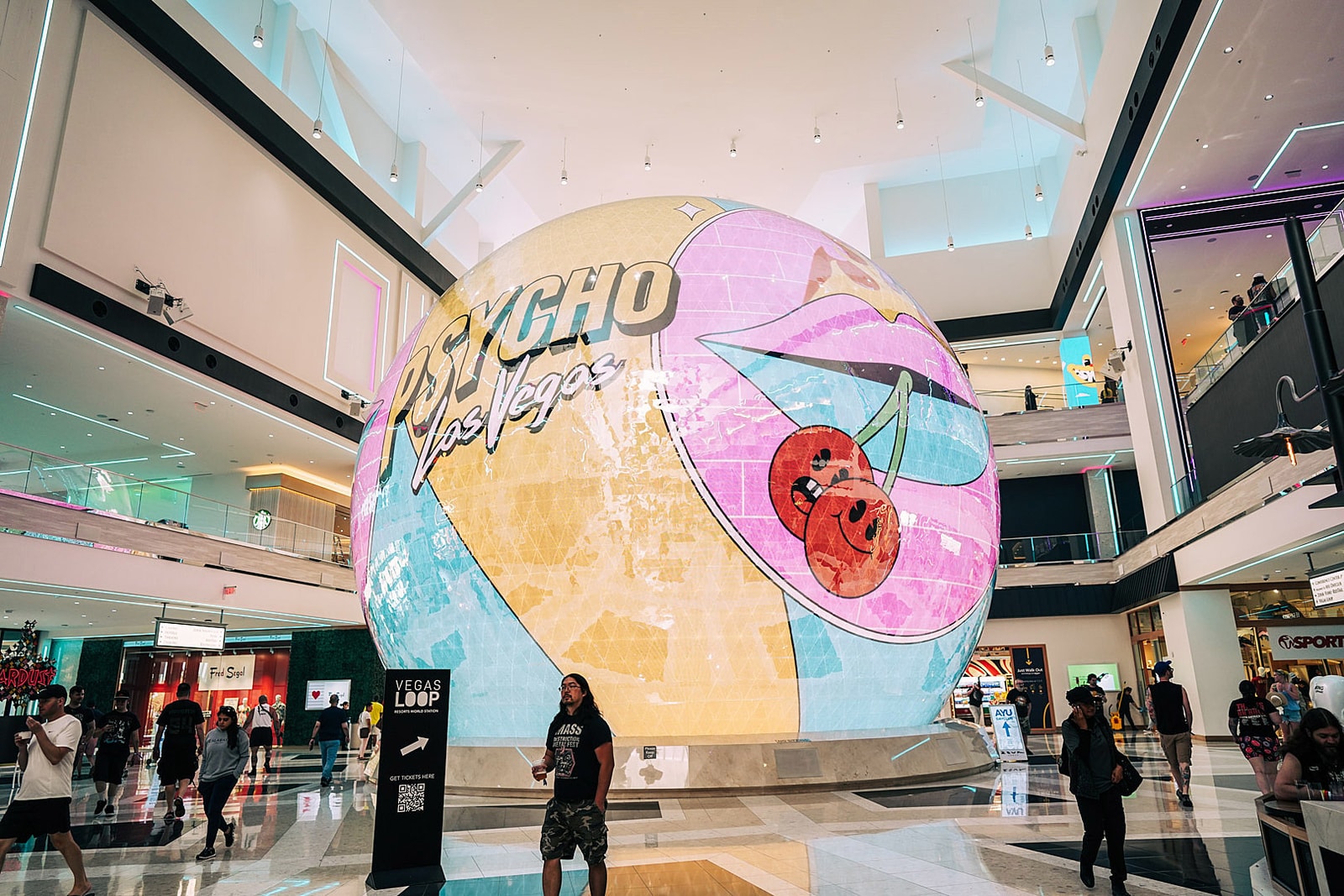 A spherical screen displays Psycho Las Vegas animation inside a resort atrium.