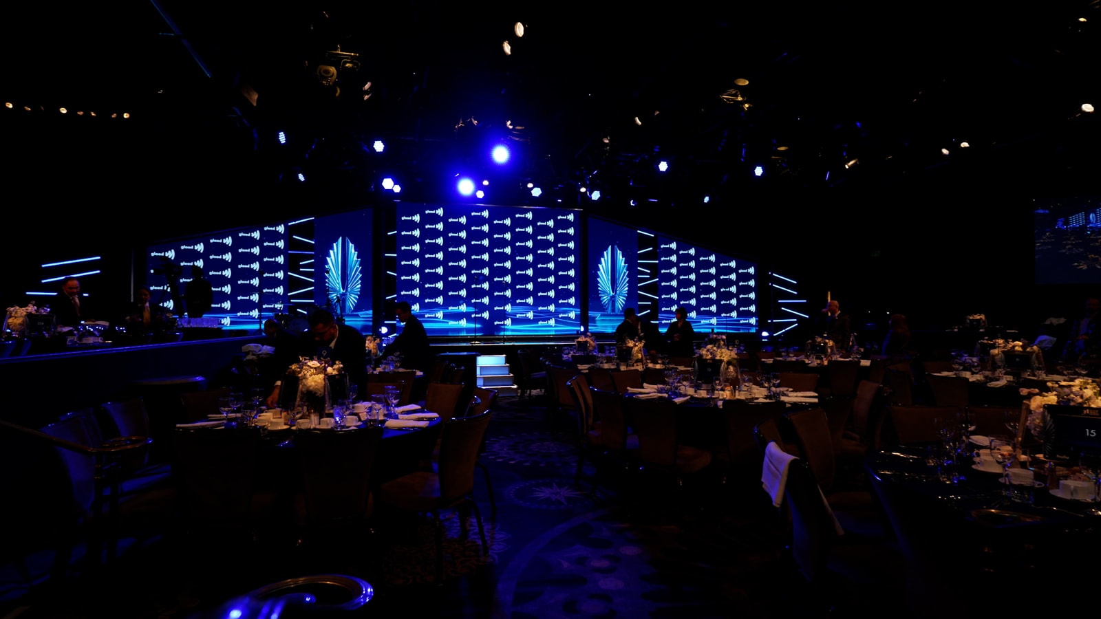 A wide view of blue stage screens and the audience at the 2023 GLAAD Media Awards.