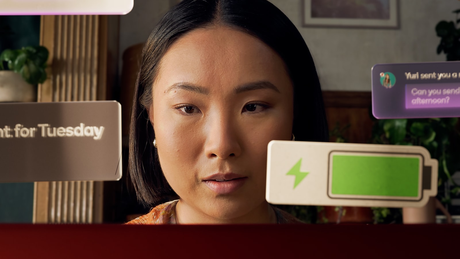A glowing battery notification floats beside a woman.
