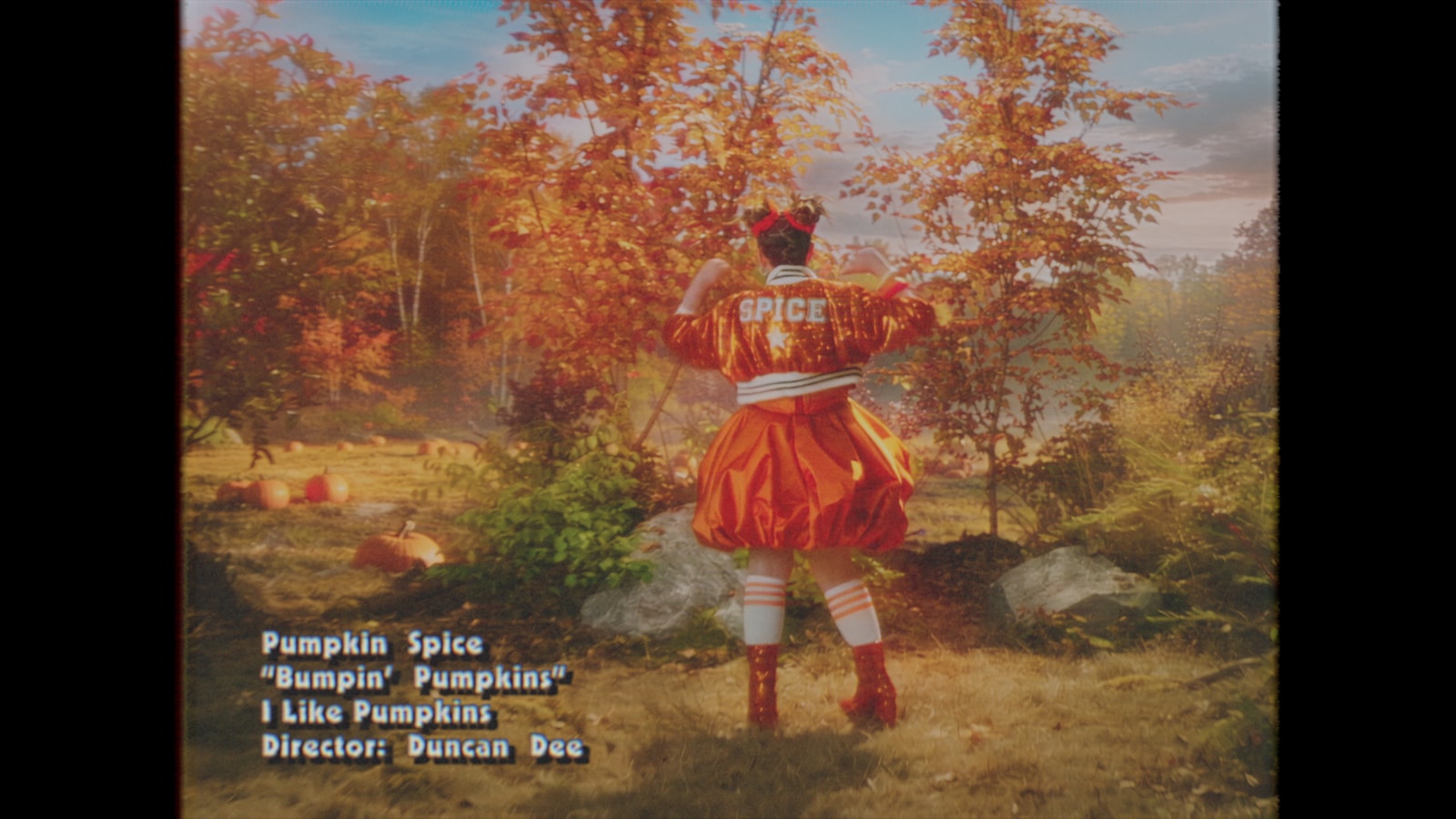 Pumpkin Spice dances in an autumn woodland in the retro music video, with on-screen song credits.