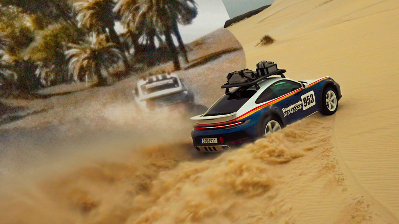 A classic Porsche rally car kicks up dust beside desert palms.