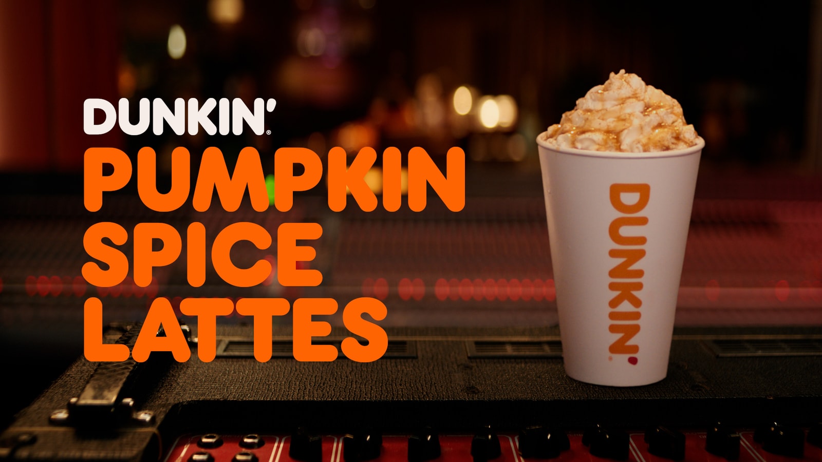 Dunkin’ Pumpkin Spice Lattes end card with a whipped-cream-topped drink on a recording-studio mixing console.