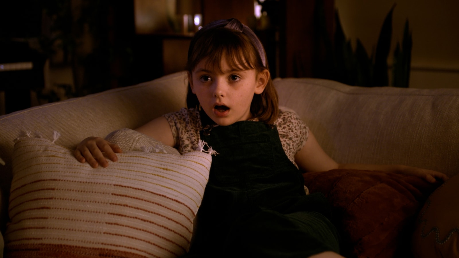 A young girl reacts with surprise from a couch in the Hershey’s Heroes spot.